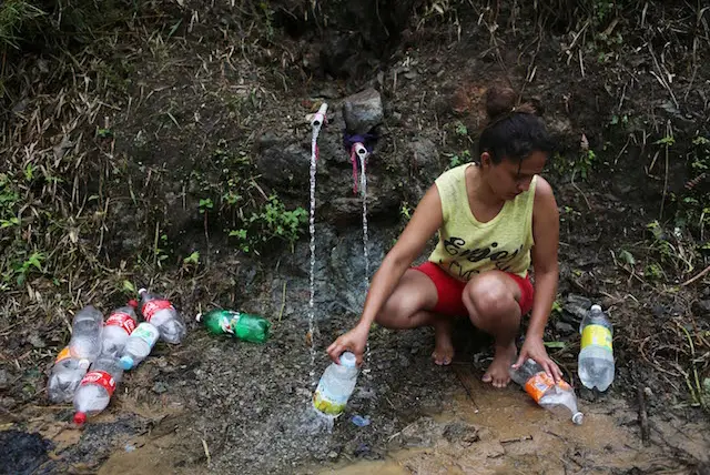 Yanira Rios collects spring water for use in her house, which is without running water or electricity, on October 10, 2017 in Utuado, Puerto Rico.